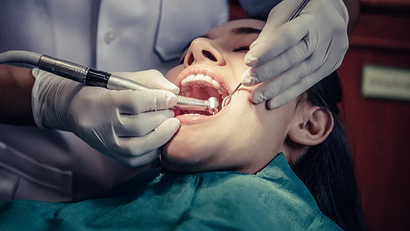 Woman at the dentist cleaning her teeth