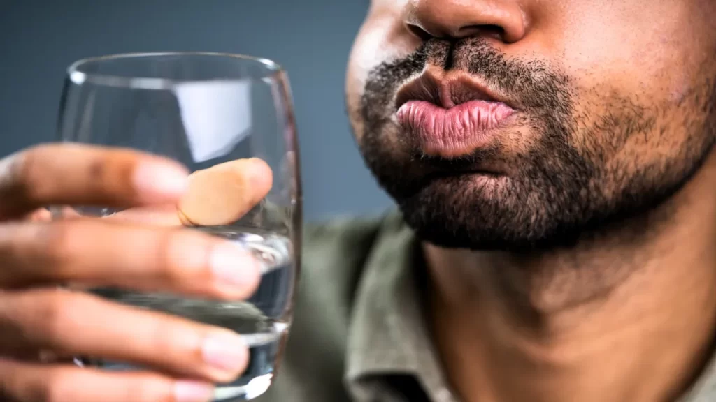 Man holding a glass of water mouth washing