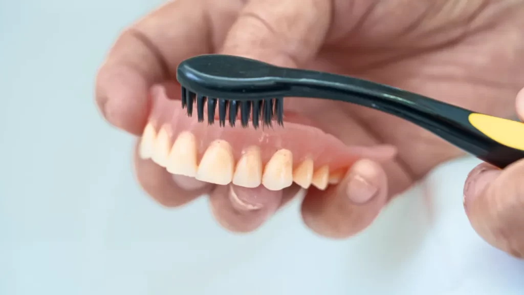 cleaning dentures with a tooth brush