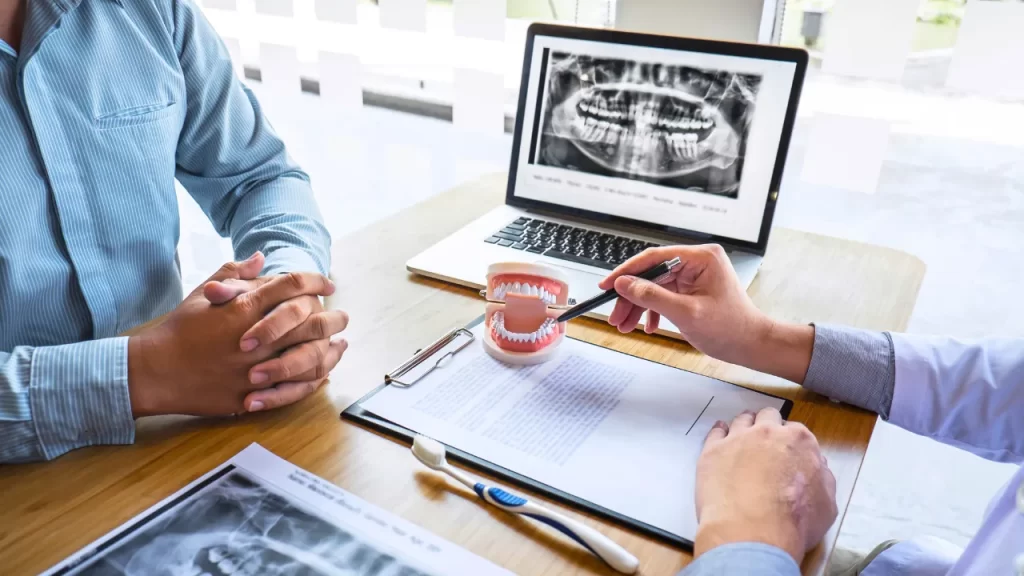 A Dentist explaining an X-ray using a dental prop