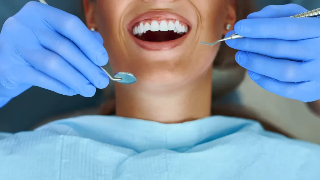 A woman smiling at the dentist getting her teeth checked