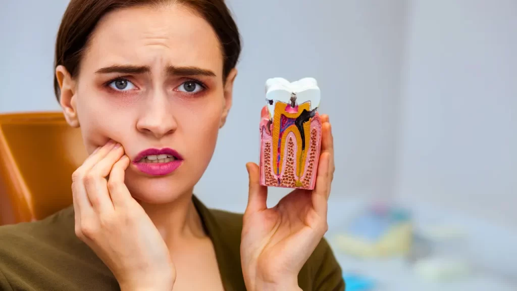 Woman holding a rotten tooth sample